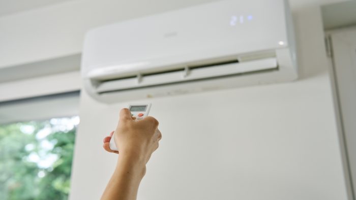 Adjusting,Air,Conditioner,Temperature,With,Remote,Control.,Hand,Holds,Remote Adjusting,Air,Conditioner,Temperature,With,Remote,Control.,Hand,Holds,Remote